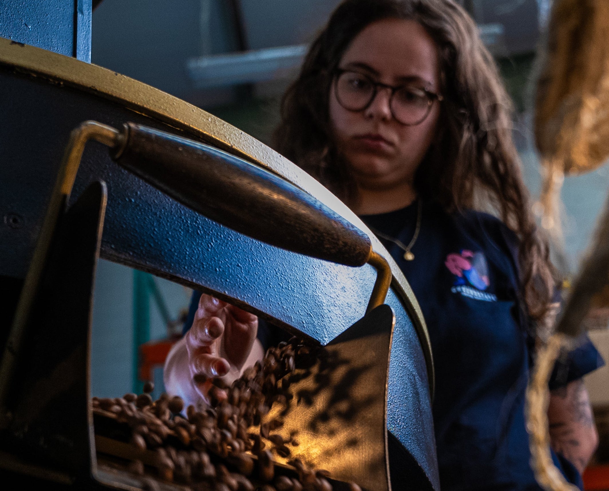 Person standing next to a machine with a reflective surface showing a person's reflection.